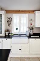 Butler sink in modern black and white country kitchen 
