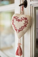 Embroidered heart decoration on key in cabinet door 