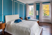 Classic bedroom with blue painted paneled walls 