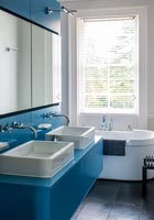 Blue sink unit and bath in modern bathroom 