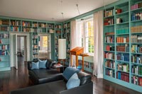Wall to wall painted wooden bookcases in classic library 