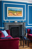 Azure blue and white painted walls and pink velvet sofas in classic living room
