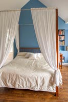 Four poster bed in blue and white bedroom 
