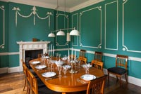 Classic dining room with paneled green and white walls 