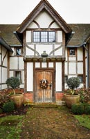 Exterior of classic country home with Christmas wreath on wooden front door