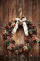 Detail of Christmas wreath on wooden front door 