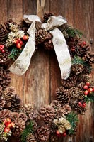 Detail of Christmas wreath on wooden front door 