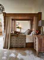 Wooden four poster bed in classic bedroom 