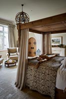 Wooden four poster bed in classic bedroom 