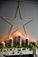 Candles and decorative star over fireplace 