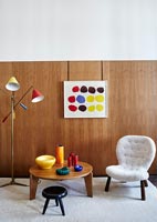 Table and chairs with wooden walls and colourful accessories 
