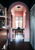 View through pink painted archway to dining table 
