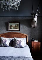 Animal head and glitter wallpaper in eclectic bedroom 