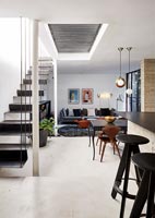 Open plan living space with suspended staircase 