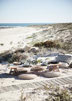 Low table and cushions on beach  