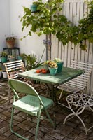 Small green cafe table and chairs on terrace 