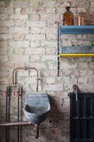 Exposed brickwork in modern bathroom with tiny concrete sink 