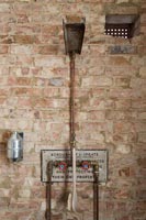 Exposed brickwork and pipes in modern bathroom 