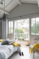Country bedroom with doors open to balcony in summer 