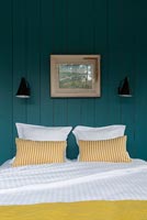 Country bedroom with blue painted wooden walls 