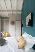 Wooden country bedroom with blue painted feature wall 