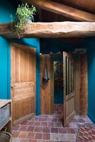 Landing with blue painted walls and exposed wooden beams 