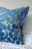 Blue velvet cushion on bed 