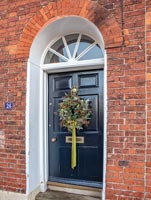 Christmas wreath on classic front door exterior 