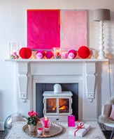 Modern artwork and paper baubles on mantelpiece 