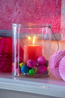 Candle in glass jar with colourful decorations 