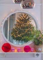 Christmas tree reflected through modern white plastic mirror 