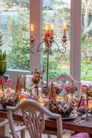 Metal crown decorations on dining table dressed for Christmas dinner 