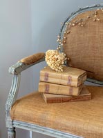 Vintage sofa with books and dried hydrangea flowers 