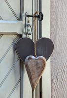 Carved wooden hearts on vintage key in door 