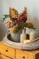 Vintage ceramic jars and bottles with dried hygrangea flowers and candle 