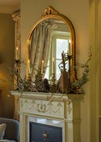 Gold mirror over fireplace decorated for Christmas 