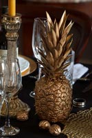 Gold sprayed pineapple and walnuts on classic dining table 