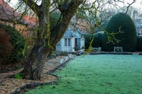Clipped hedge and summer house in country garden - winter 