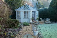 Summer house with lit firepit in country garden - December 