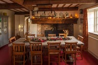 Country dining room with large fireplace - Christmas garland on table 