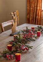 Angel candle holder and Christmas garland on wooden table 