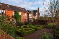 Exterior of large 15th Century country house with formal parterre 