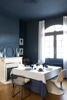 Dark blue dining room with white furnishings 