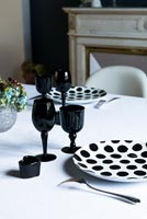 Black and white crockery and glassware on dining table 