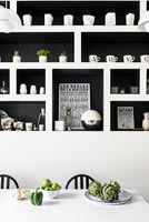 Modern built-in shelving unit in black and white kitchen diner 