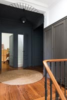 Black painted wall and wooden floor on classic upstairs landing 