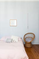Pale blue painted walls and pink bedspread in classic childrens bedroom 