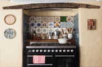 Large range cooker in country kitchen with decorative tiling 