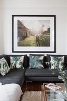 Large framed photograph over black sofa 