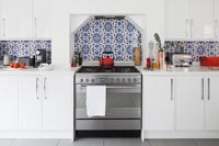 Modern white kitchen with patterned blue tiles 